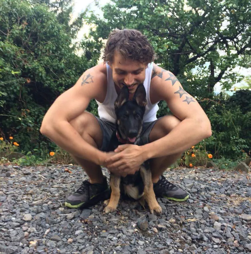 Tim Veninga zit gehurkt met zijn hond in zijn armen